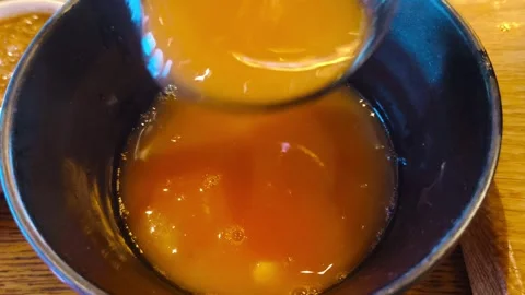 Close-up view of hot rich steaming tomato soup being poured into a black empty b Stockbeeldmateriaal 318260803