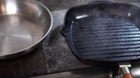 Close up view on hot steam coming up from black grill frying pan in slow motion Stock Footage 105896802