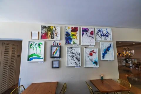 Close up view of hotel cafe wall decorated with abstract colorful paintings Stock Photos