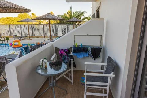 Close up view of hotel patio with table chairs drying clothes and pool area Stock Photos