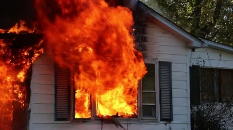 Close view of a house on fire.  Windows fully involved Stock Footage