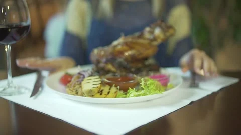 Close up view on huge fried piece of meat on vegetable plate woman hands tapping Stockbeeldmateriaal 137537477