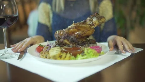 Close up view on huge grilled fried piece of meat on vegetable plate woman hands Stock Footage 137537442