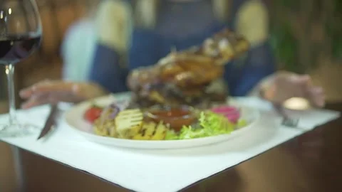 Close up view on huge grilled piece of meat on vegetable plate woman hands tappi Stock Footage 137537437