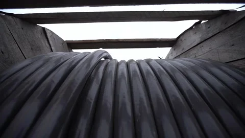 Close up view of a huge roll of cable on a wooden frame, construction site Stock Footage 160812245