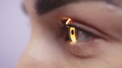 Close-up view of a human eye illuminated by a narrow beam of light, showcasing Stock Footage 337285863