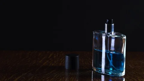Close-up view of human hand and spray bottle isolated on black parfume Stock Footage 124659458