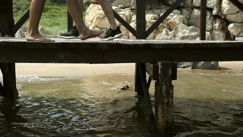 Close-up view of humans legs walking around on sea pier Stock Footage 94687604