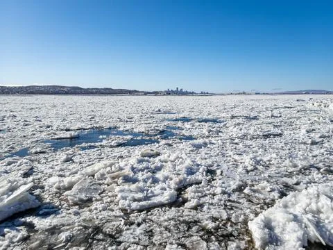 Close view of ice floating on St-Lawrence river with a view of Quebec city .. Stock Photos