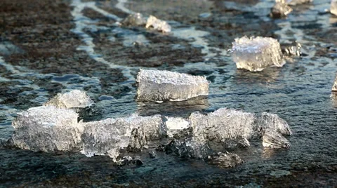 Close-up view of ice melting on a lakeside rock Stock Footage 37055570