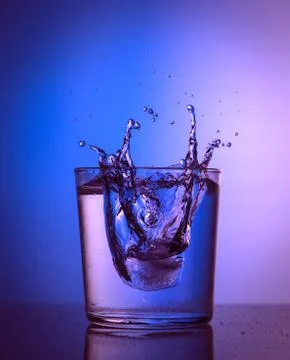 Close up view of the ice splash in water on pink and blue colors Stock Photos