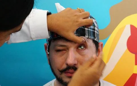 Close-up view of Indian doctor checking patient eye to insert contact lens in Stock Photos
