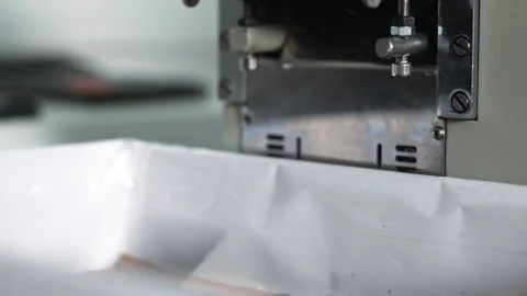 A close view of an industrial blade press cutting stacked black technical fabric Stock Footage 321889006