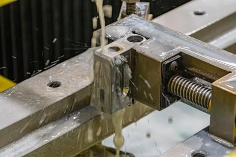 Close-up view of an industrial machine ejecting liquid, predominantly metalli Foto stock