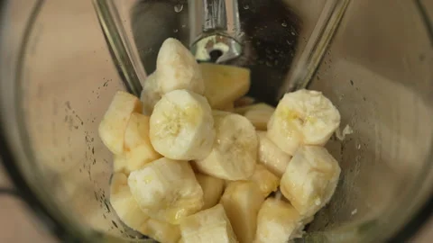 A close-up view inside a blender, where a woman's hands squeeze lemon juice.. Stock Footage 342742543