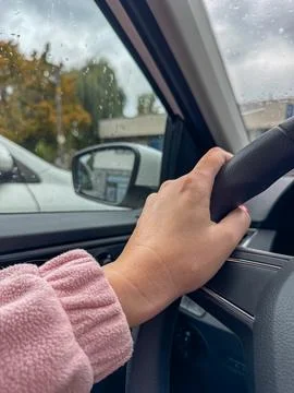 Close view from inside a car of a womans hand gripping the steering wheel on 스톡 사진