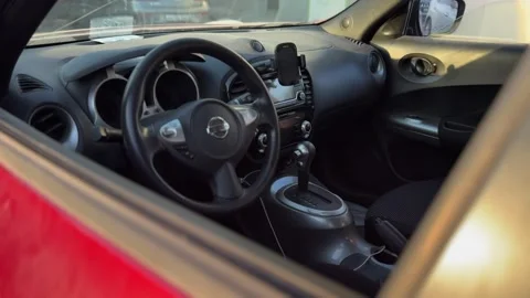 Close-up view inside a Nissan vehicle showing the steering wheel with logo Stock Footage 331110591