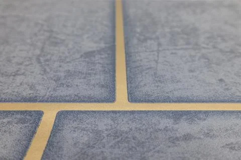 Close up view of installed blue ceramic floor tiles with beige grout lines 库存照片