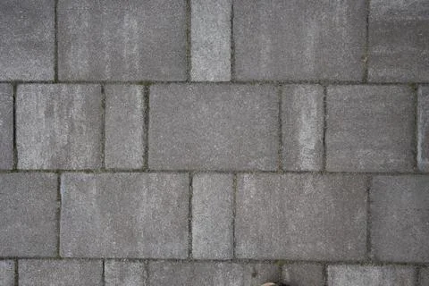 Close-up view of interlocking gray pavement blocks, showcasing texture and Stock Photos