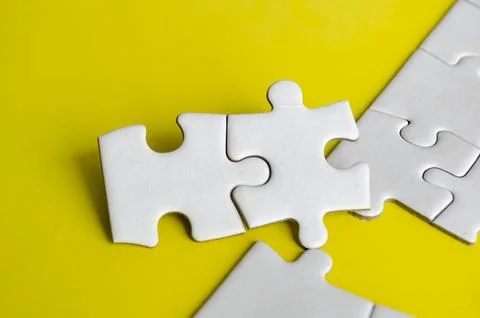 Close up view of interlocking jigsaw puzzle pieces symbolizing problem solv.. Stock Photos