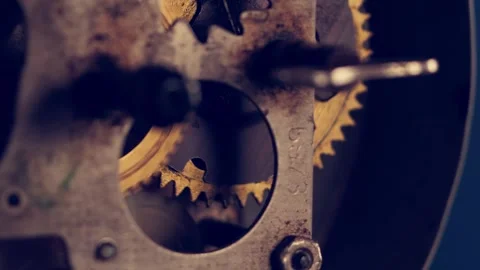 Close-up view of intricate clock mechanism showcasing gold gears in motion with Stockbeeldmateriaal 297598337