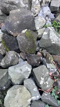 A close view of irregular dark and light gray stones stacked together, with s Stock Photos