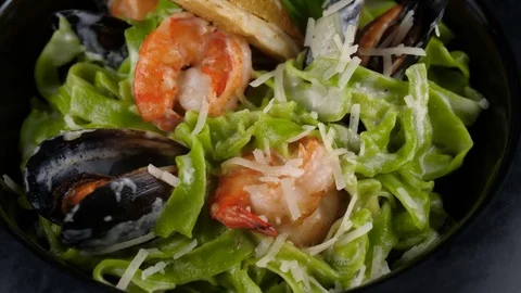 Close-up view of Italian green pasta, mussels, shrimps, parmesan cheese Stock-Footage 80709734