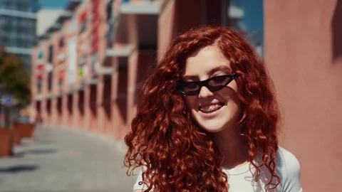 Close up view of joyful curly ginger teenage girl in hipster trendy sunglasses Stock Footage 114247443