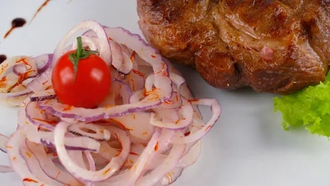 Close-up view of juicy Veal Steak with tomato, onion and lettuce leaf Stock Footage 79711065