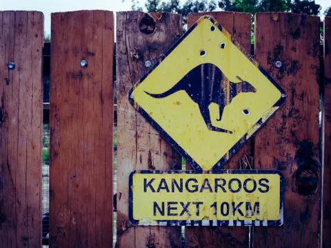 Close up view of Kangaroo next 10 km sign on a wooden fence Stock Photos
