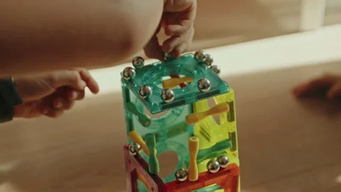 Close up view of a kids hands playing, building tower from colorful figures Stock Footage 253344351