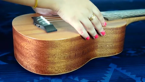 Close view of kids playing ukulele. Kids playing musical instrument 動画素材 150696106