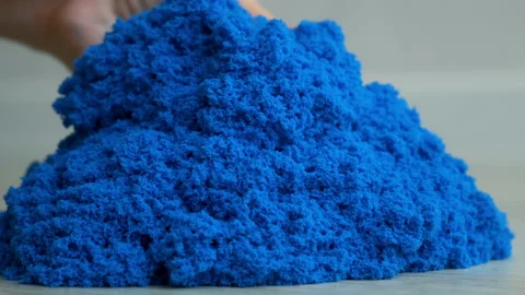 Close-up view kinetic sand of bright blue color for play in woman's hands. Stock Footage 167763452