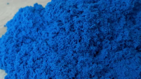 Close-up view kinetic sand of bright blue color for play in woman's hands. Stock Footage 168005528