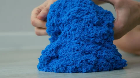 Close-up view kinetic sand of bright blue color for play in woman's hands. Stock Footage 169085234