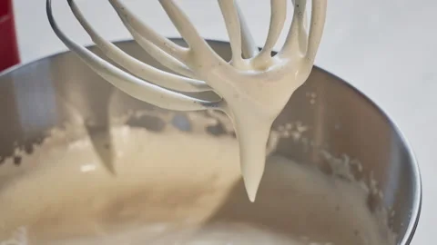 Close-up view of a kitchen mixer from which a beaten egg with sugar slowly flows Stock Footage 309296979