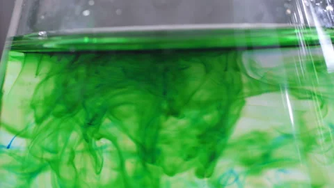 Close up view of laboratory beaker with green colorant dissolving. Stock Footage 110413634