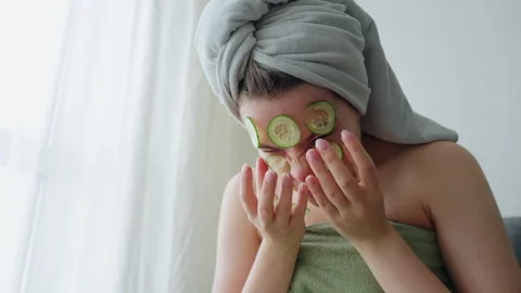 Close View of Lady Squeezing Face While Removing Cucumber Slices from Face Stock Footage 308593118