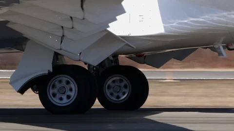 A close up view of landing gear assembly and wheels rolling on tarmac Stock-Footage 119699401