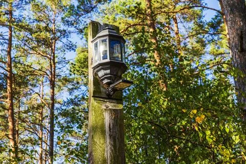 Close-up view of lantern and floodlight on wooden post against background Stock Photos