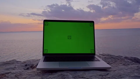 Close View of Laptop With Green Screen on a Coastal Rock at Sunset, Digital Mock Stock Footage 339022749