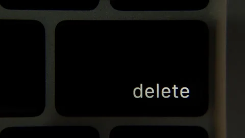 Close view of a laptop keyboard where the Delete key label lights up as the 库存影片 330522842
