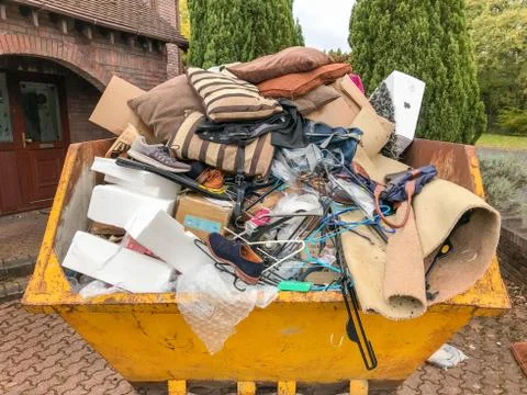Close up view of a large heavy skip filled with rubbish from a house clearance Stock Photos