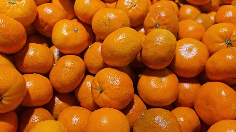 A close-up view of a large pile of bright, ripe, and vibrant orange Clementine 스톡 동영상 322933837