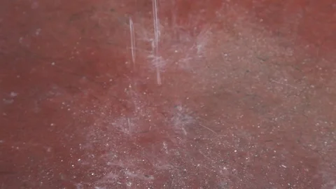 Close-up view of large raindrops hitting pavement near Nepal hotel. Stock Footage 86758360