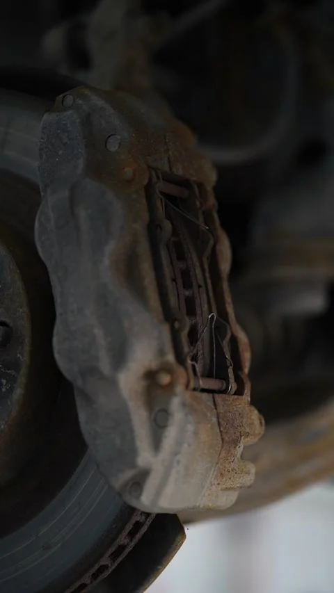 A close-up view of a large rusty multi-piston car brake Stock Footage 343551377