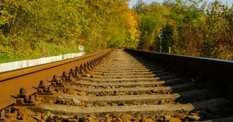 A close-up view of the large screws securing the train tracks during a sunny  Stock-Fotos