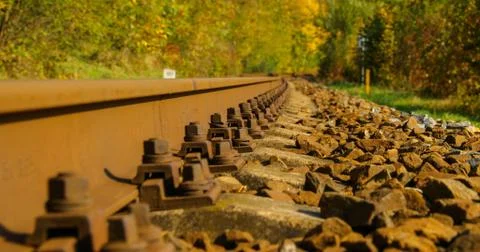 A close-up view of the large screws securing the train tracks during a sunny  Stock-Fotos