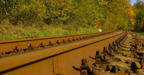 A close-up view of the large screws securing the train tracks during a sunny  Stock-Fotos