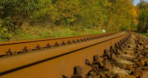 A close-up view of the large screws securing the train tracks during a sunny  Фото